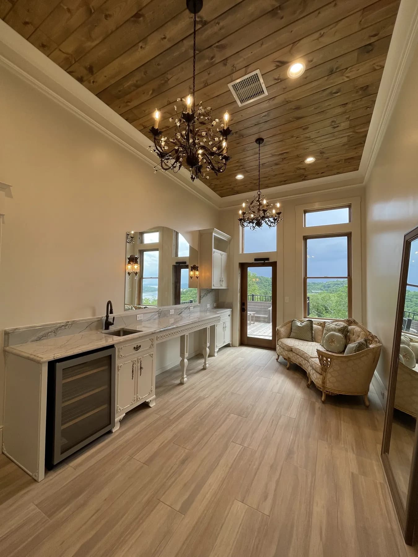 Wet bar with a marble top beneath the vaulted plank ceiling