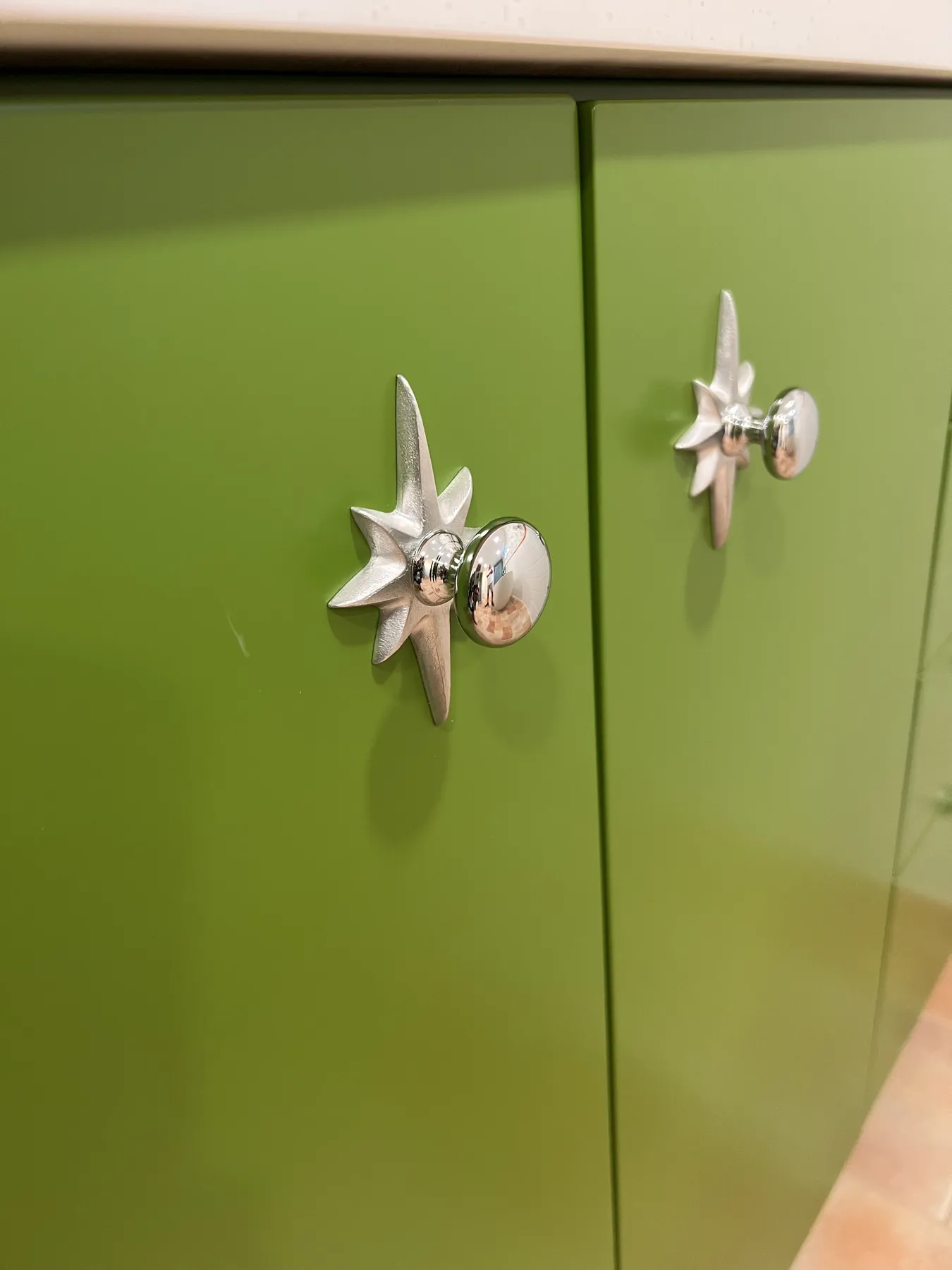 Cast starfish knobs on the green lacquered doors
