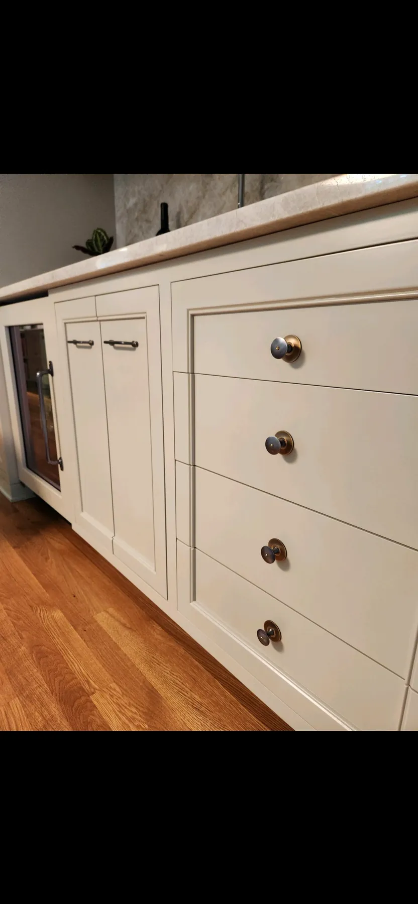 Painted dresser-style cabinets with bronze knobs