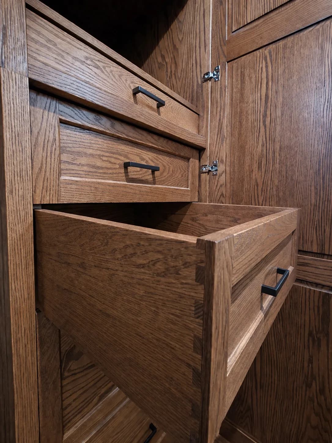 Oak drawer with dovetailed sides pulled out of the wardrobe