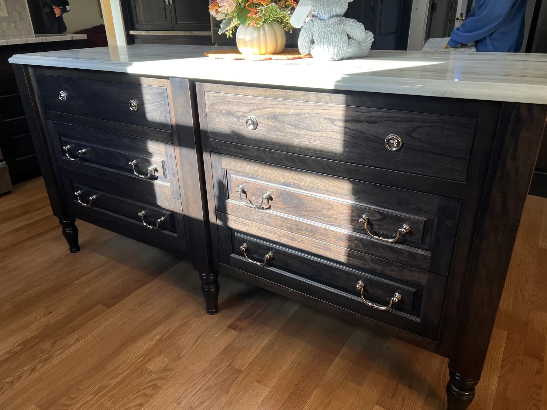 Furniture-style stained island with turned legs and antique brass pulls