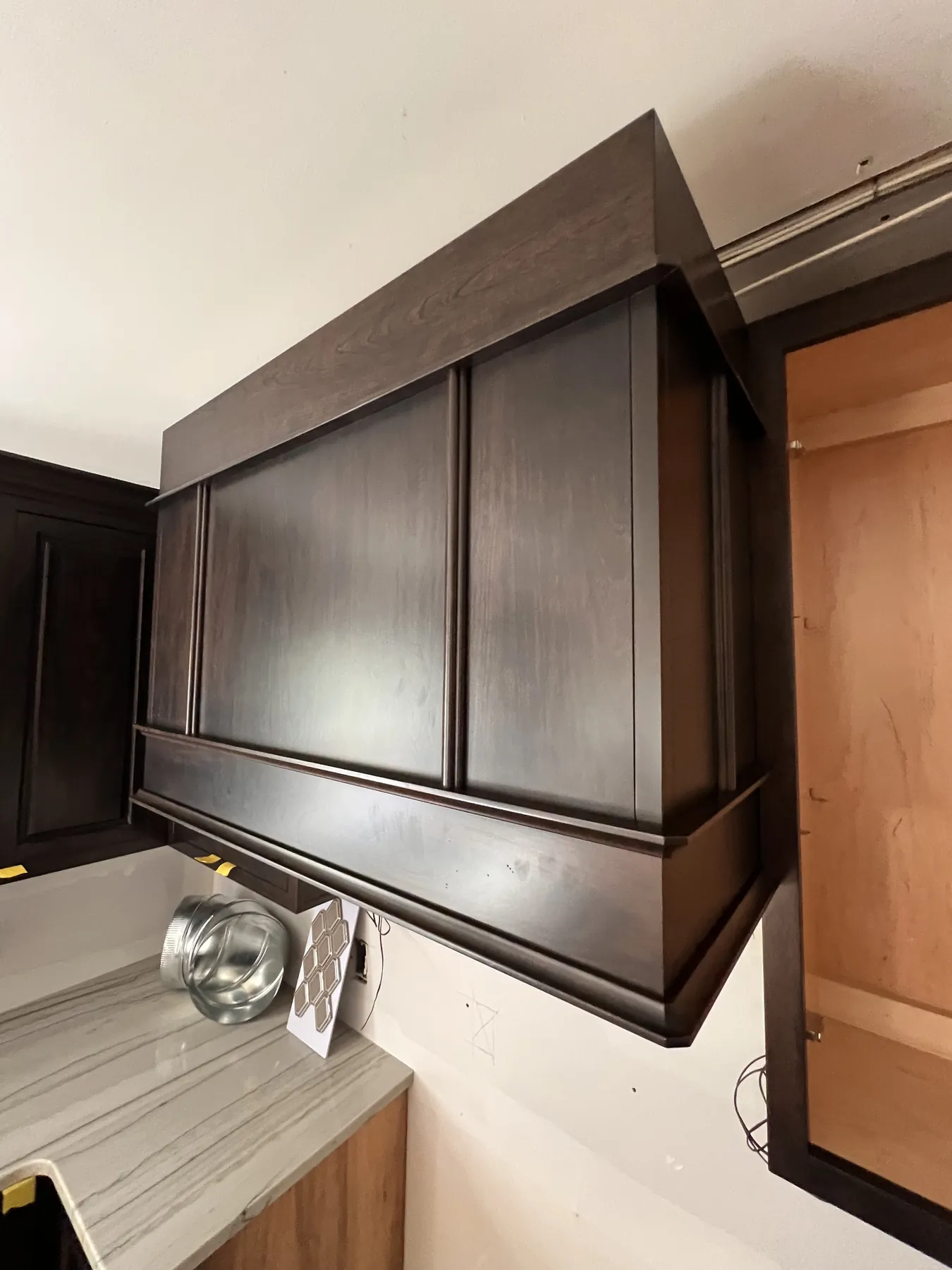 Stained panelled hood over the range wall