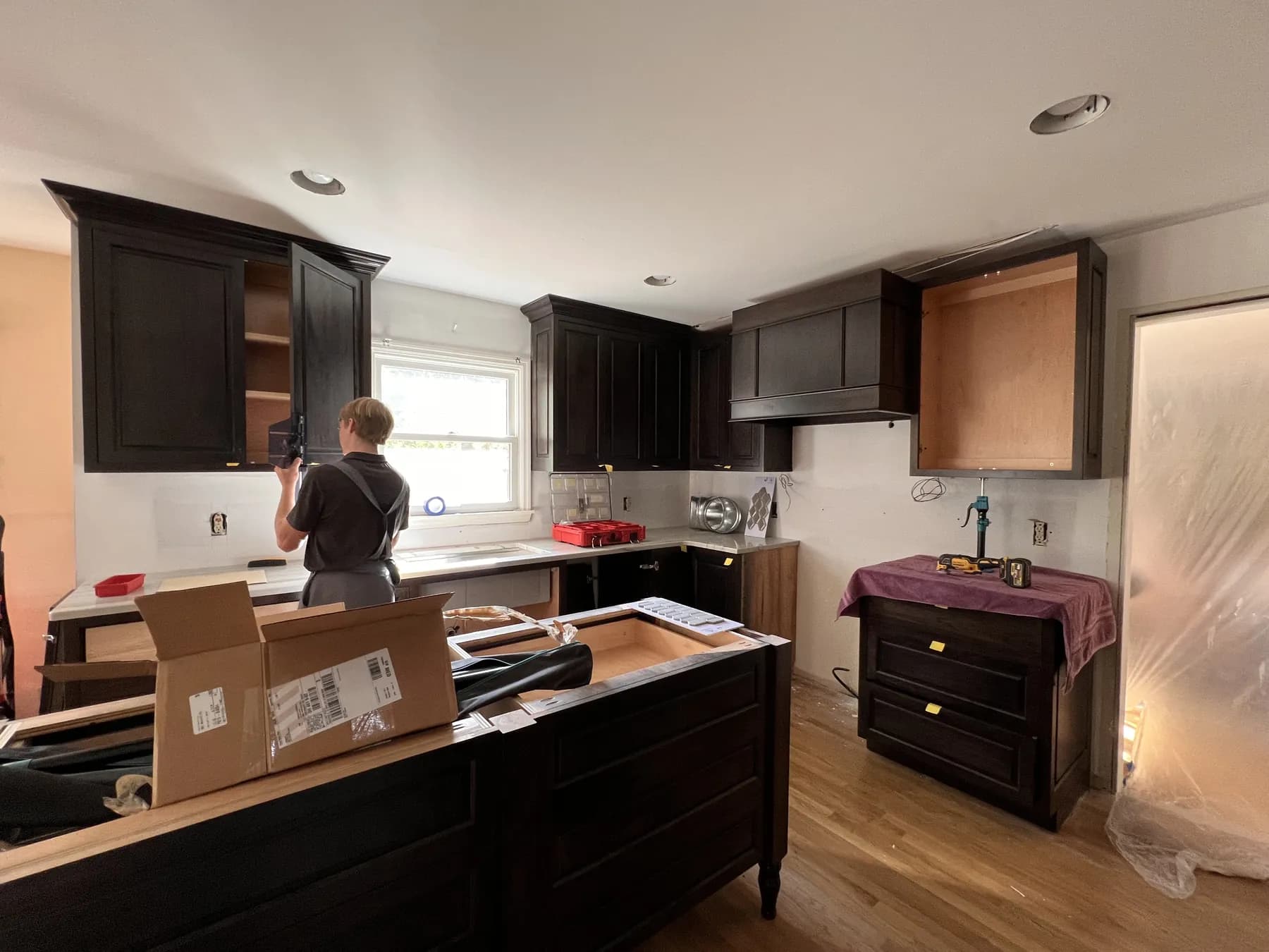 Fitting the stained kitchen cabinets during install