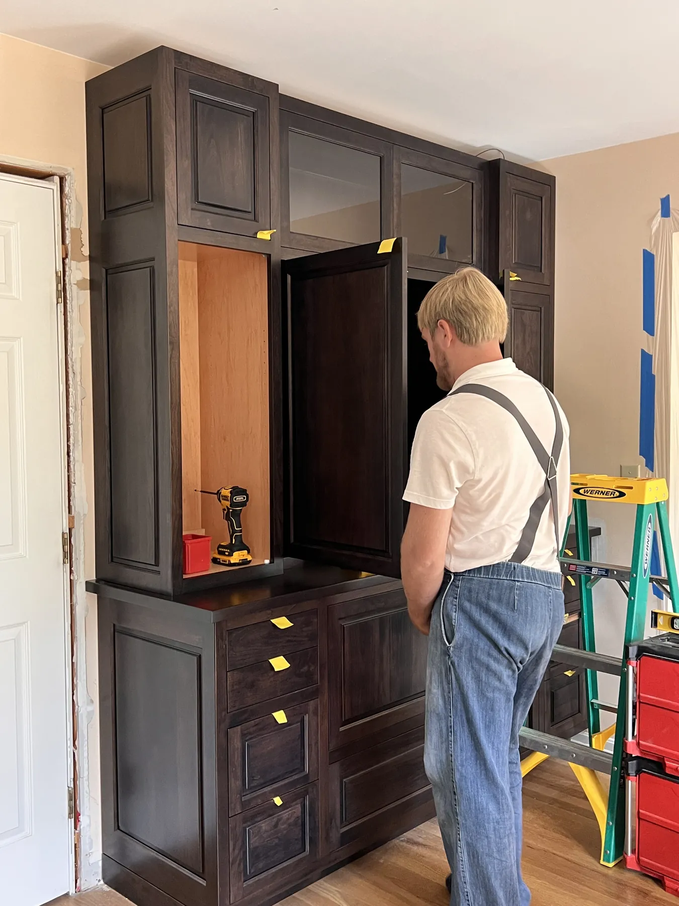 Installing the stained tall cabinets and drawer bank