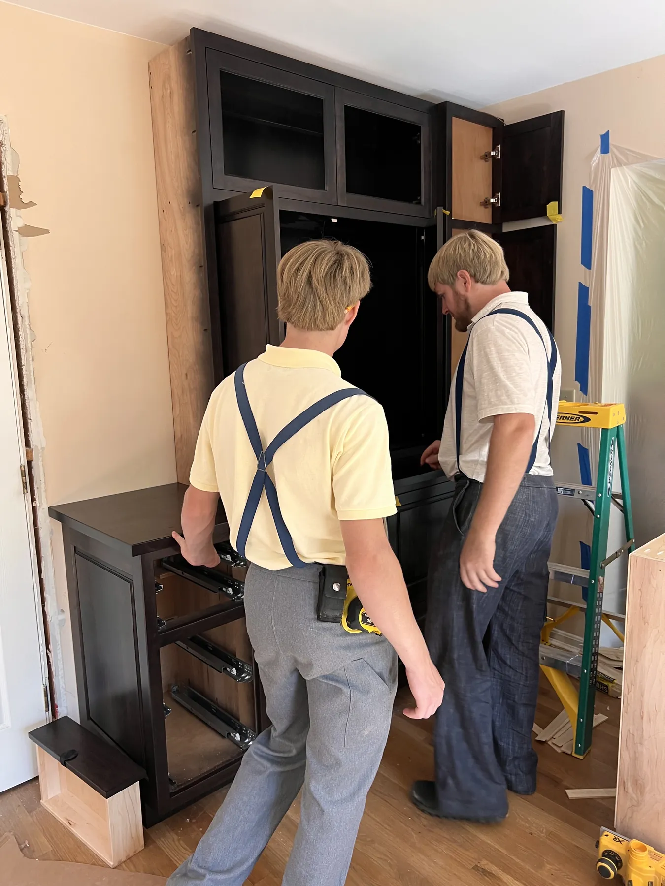 Two of the crew setting a stained cabinet run on site