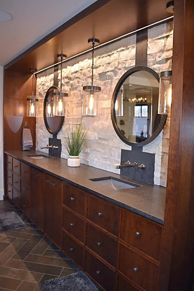 Round mirrors and pendant lights above the stained double vanity