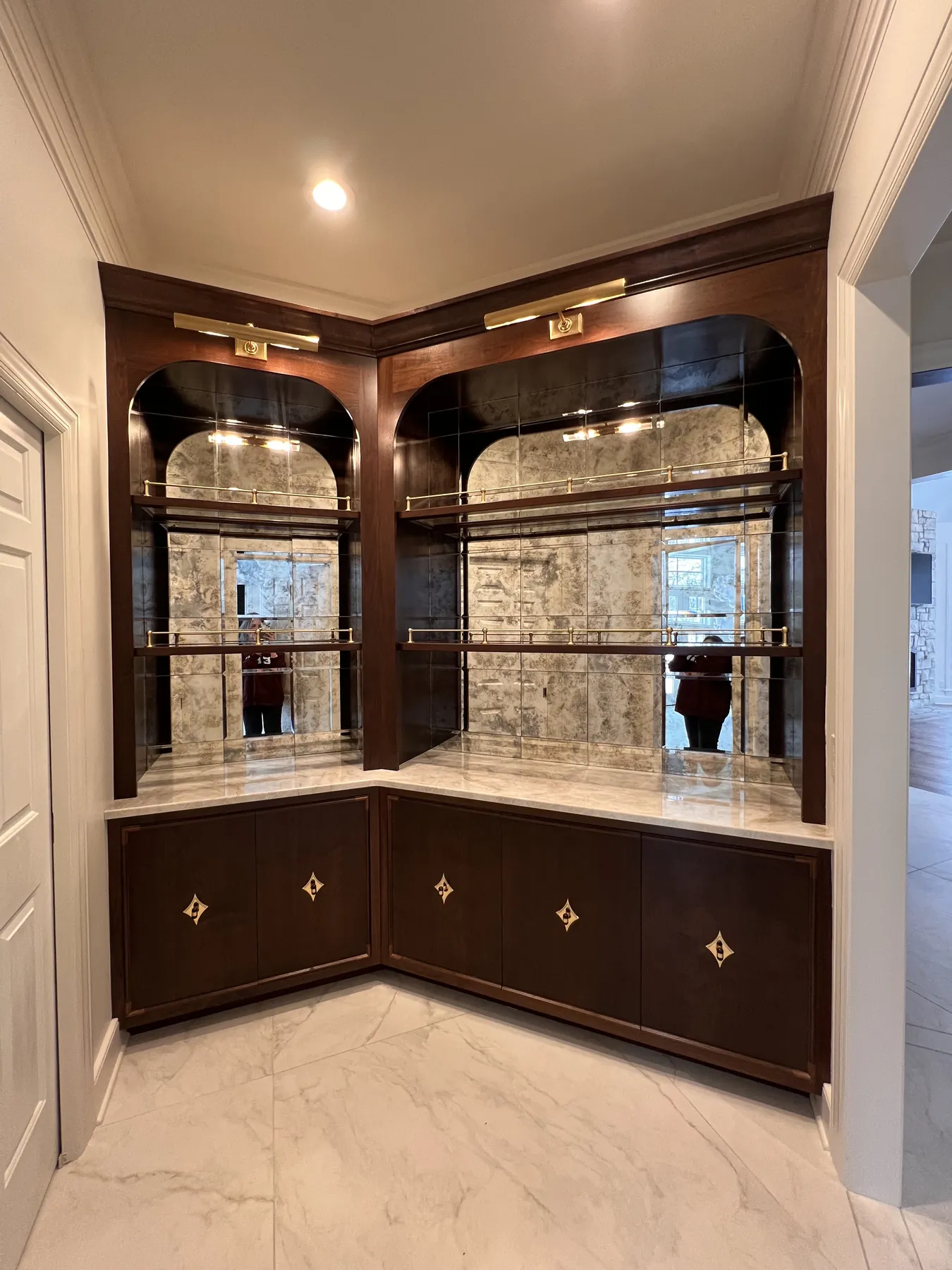 Corner bar with two arched mirrored bays over inlaid walnut base cabinets