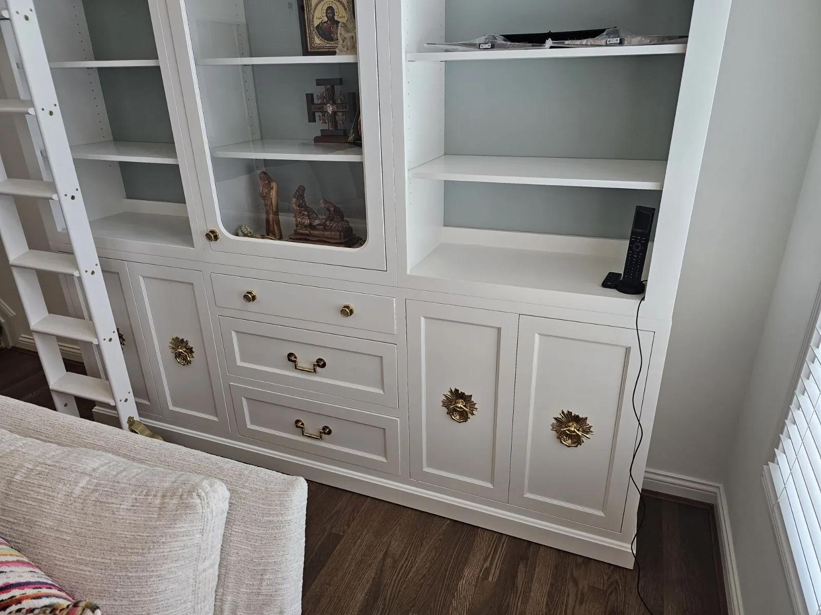 Painted built-in with glass-front upper shelves and cabinets below