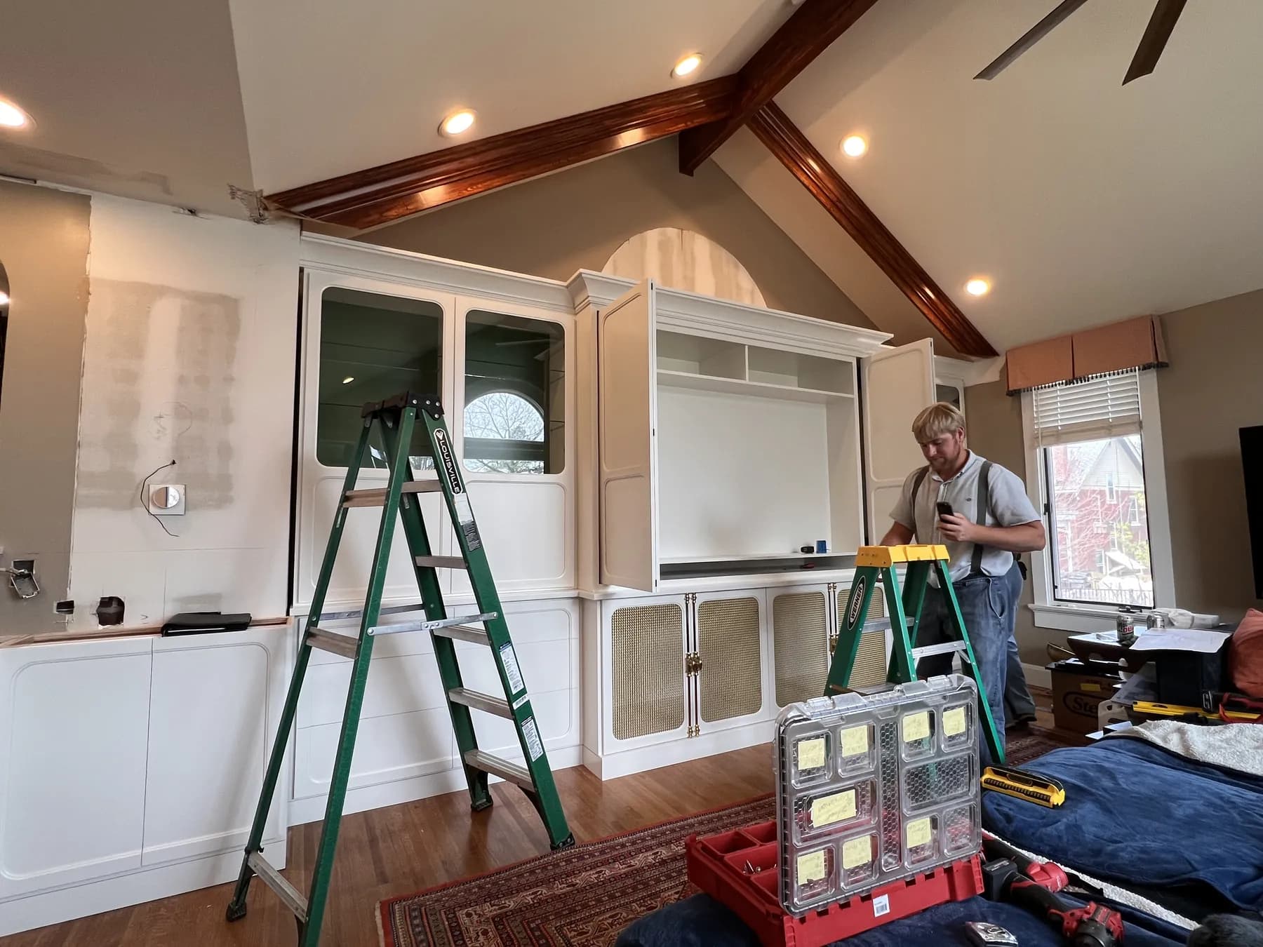 Painted built-ins going in beneath a vaulted beam ceiling