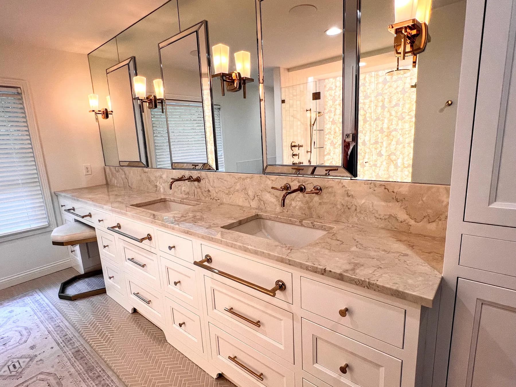Painted double vanity with a marble top, brass bar pulls and framed mirrors