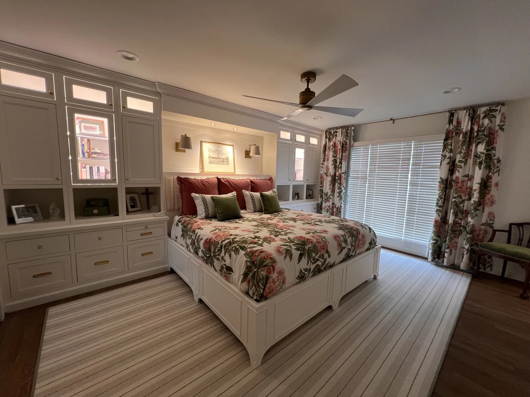 Painted bedroom built-ins with display niches and a bench beside the bed