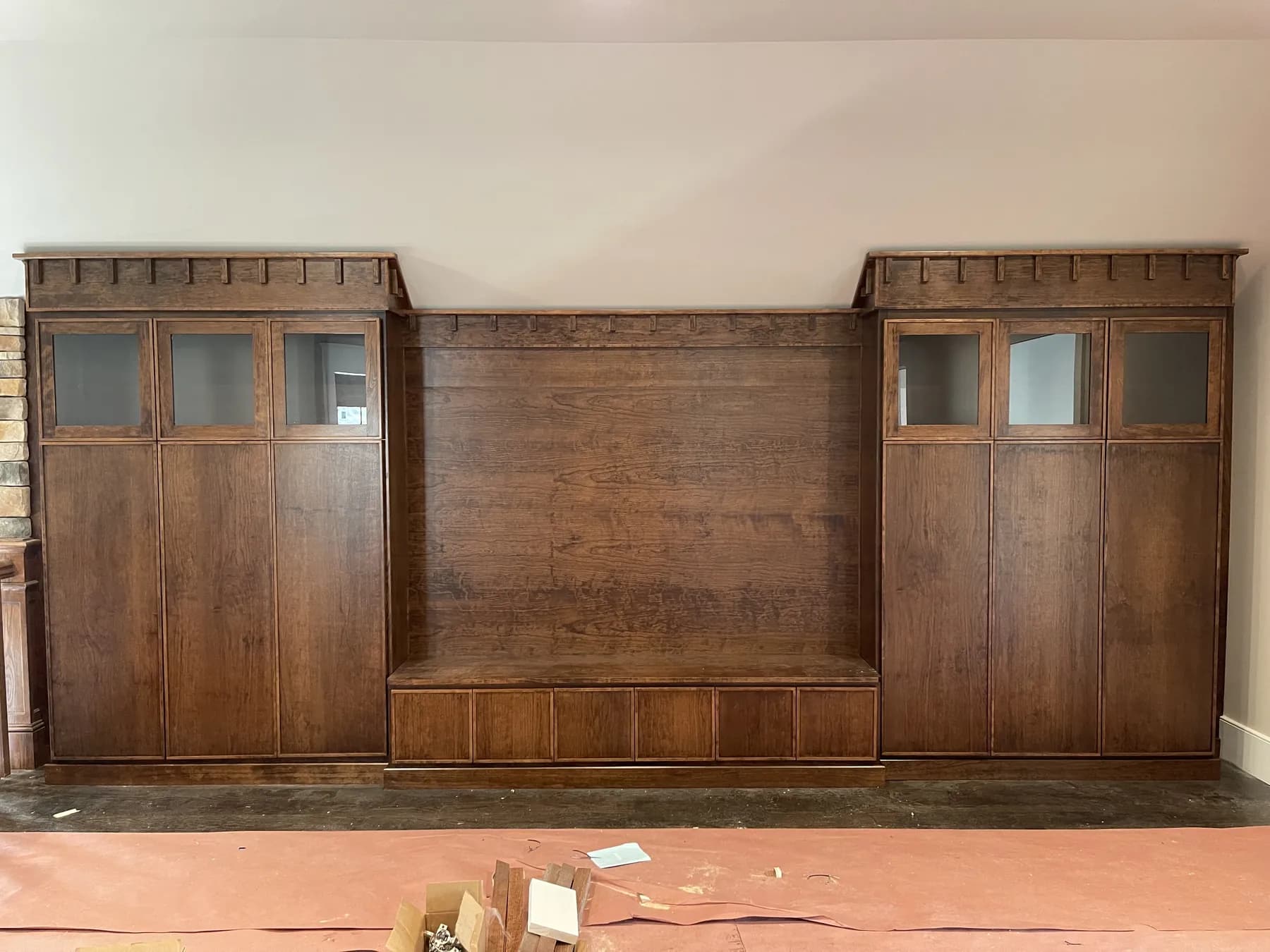Stained panelled bed wall with built-in cabinets, before finishing